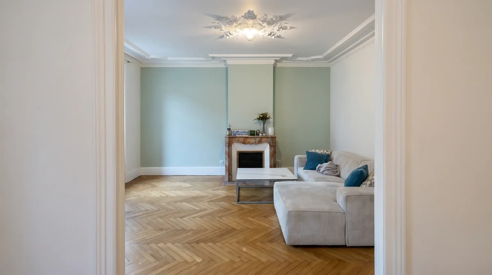Intérieur en cours de rénovation avec murs en plaques de plâtre non finies, échelle en bois positionnée au centre, pot de peinture rouge et rouleau au sol